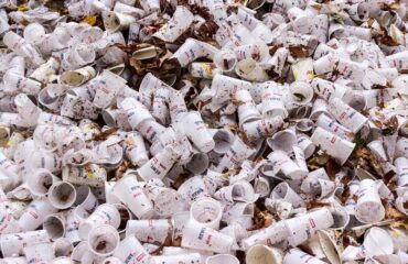 Piles of disposable plastic cups contributing to plastic waste – reduce plastic waste
