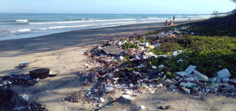 Plastic waste and debris covering a beach shoreline – highlighting the urgent need for action against ocean plastic pollution.