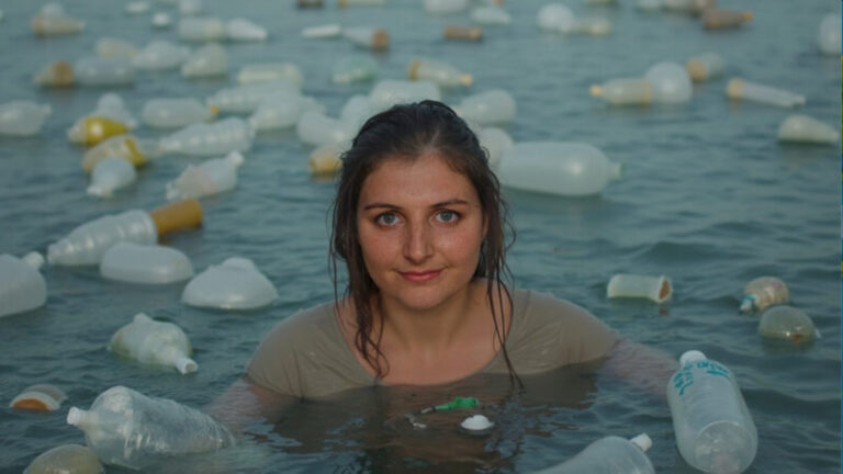 Woman surrounded by plastic bottles floating in water, created for an AI environmental awareness campaign by Ocean Material to illustrate global plastic pollution